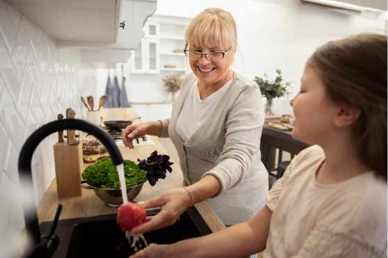Support worker helping a young participant in the kitchen
